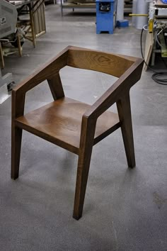 a wooden chair sitting on top of a floor in a room filled with other furniture