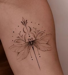 a woman's thigh with a flower tattoo on it and an arrow in the center