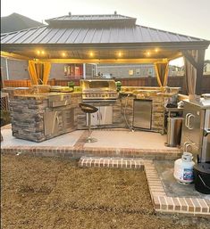 an outdoor kitchen and grill area in a backyard