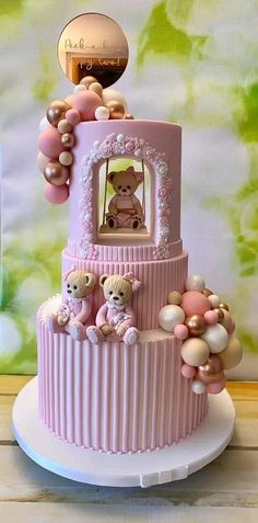 a pink and white cake with teddy bears on top