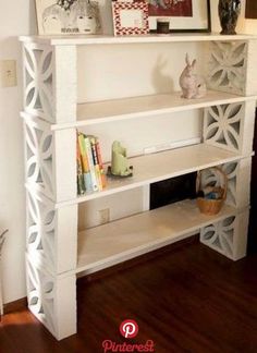 a white shelf with books and pictures on it