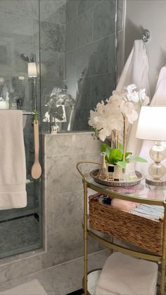 a bathroom with a glass shower door and white towels hanging on the rack next to it