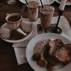 there is a plate with some food on it and two cups of coffee next to it