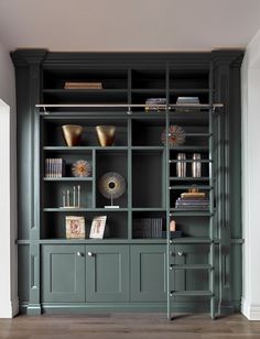 a green bookcase with books and vases on it