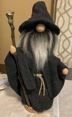 an old wizard doll holding a stick on top of a table