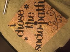 a gold graduation cap with the words god's cross on it and a pen