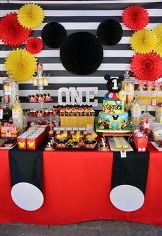 a mickey mouse themed birthday party with lots of food and desserts on the table