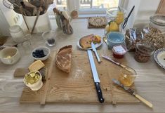 a wooden cutting board topped with lots of different types of food and condiments