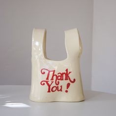 a white plastic bag with the words thank you written on it and a red handle