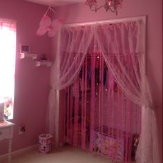 a room with pink walls and curtains in it