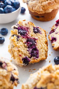 muffins with blueberries are on a white surface