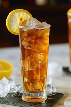 a glass filled with ice and lemon on top of a table