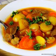 a white bowl filled with stew and vegetables