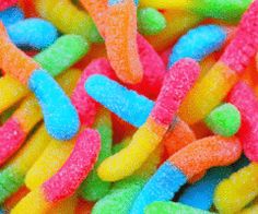 a pile of colorful candy worms with the caption repost and like if u like any of these