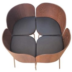 four wooden chairs with black leather seats on each side and one is shaped like a flower