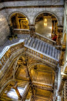 an aerial view of the inside of a building, looking down at stairs and arches