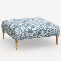 a blue and white ottoman with wooden legs