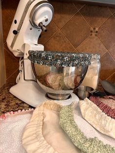 a white mixer sitting on top of a kitchen counter next to a green and white towel