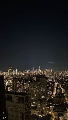 the city skyline is lit up at night with skyscrapers in the foreground and lights on all sides