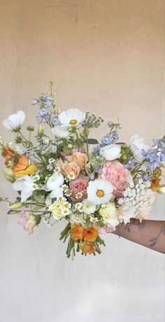 a woman holding a bouquet of flowers in her hand