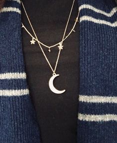 a woman wearing a necklace with a crescent and stars on it