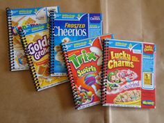 three notebooks are lined up next to each other on a brown paper bag with cereal