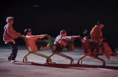 three people pushing two shopping carts in the dark