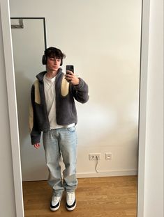 a young man taking a selfie in front of a mirror with headphones on