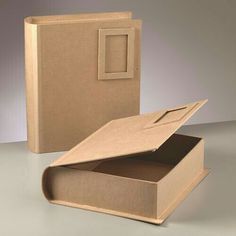 an open cardboard box sitting on top of a table next to a closed book case