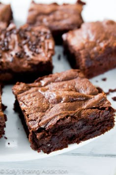 chocolate brownies with white frosting sitting on wax paper