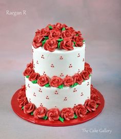 a three tiered cake with red roses on the top and bottom, sitting on a red plate