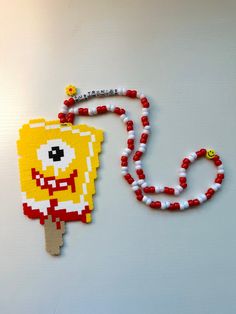 a piece of art made to look like a pac - man on a beaded necklace