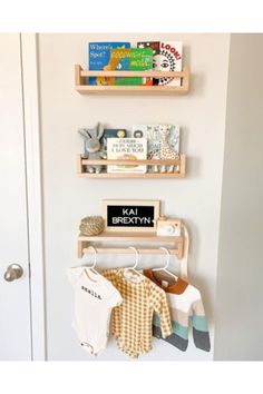 two wooden shelves holding books and baby clothes