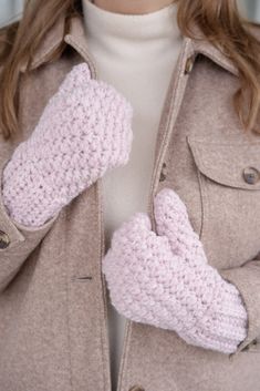 a close up of a person wearing mittens and a jacket with buttons on it