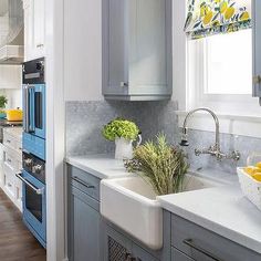 a kitchen with blue cabinets and white counter tops