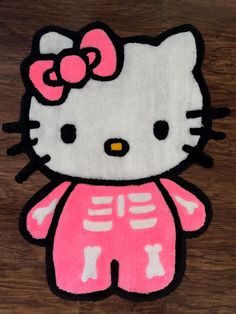 a hello kitty skeleton rug on a wooden floor with the word hello kitty written across it