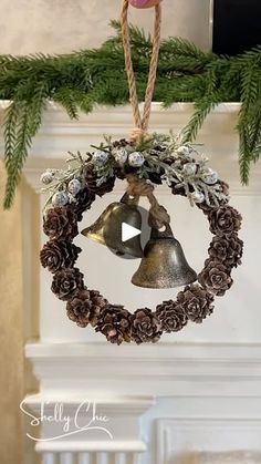 a christmas ornament hanging from a tree with pine cones and bells on it