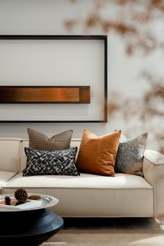 a living room with a white couch and pillows