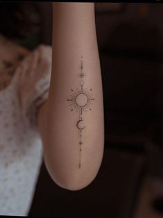 a woman's arm with a sun and moon tattoo on the left side of her body