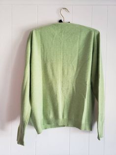 This is a vintage cardigan sweater. It is green, long sleeved and has Mother of Pearl buttons. I do not know its size as there is no label. Please refer to the measurements for a proper fit. I think this sweater is possibly lambswool or angora. I am not sure due to the missing label. Please note, there are 2 or 3 spots that are a bit dark. I dont think these are stains, just little dark marks in the fibers. They are evident in the 4th and 5th pictures. Please feel free to ask to see an image. Th Retro Green V-neck Sweater, Green Long Sleeve Cardigan, Green Cotton V-neck Cardigan, Green Cotton Long Sleeve Cardigan, Classic Green Cotton Cardigan, Green Crew Neck Winter Cardigan, Green Crew Neck Cardigan For Winter, Vintage Green Long Sleeve Cardigan, Classic Green Long Sleeve Sweater