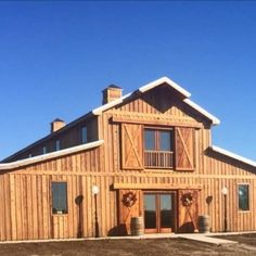 a large wooden building sitting on top of a dirt field