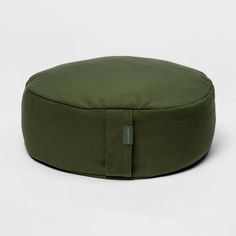 an olive green round poufce cushion on a white background