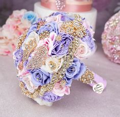 a bridal bouquet with purple and pink flowers on it, sitting next to other wedding accessories