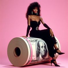 a woman sitting on top of a roll of money