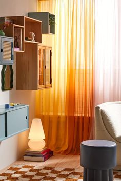 a living room filled with furniture and a window covered in orange draping next to a white couch