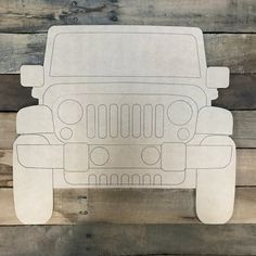 a paper cutout of a jeep on wooden planks