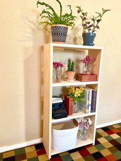 a book shelf with flowers and books on it