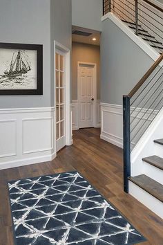 a staircase leading up to a second story with white walls and wood flooring on the other side