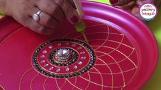 a person holding a pink frisbee on top of a green and yellow table