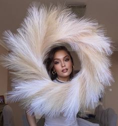 a woman in white dress with large fur around her neck